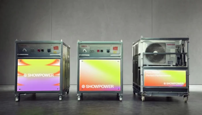 Row of three Showpower battery power units in signature lime, orange and lilac branding, sustainable energy systems for festivals and live events